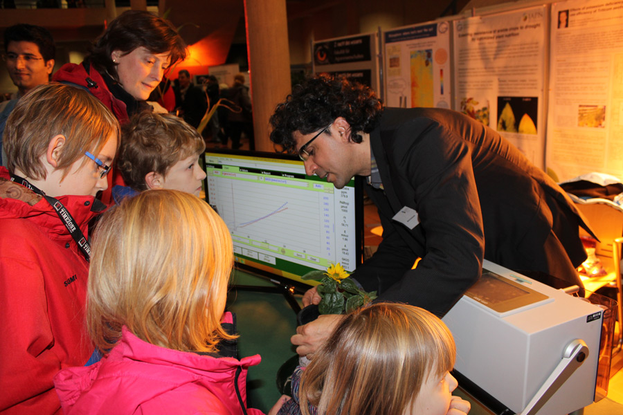 Reges Interesse bei Klein und Gro&szlig;: Juniorprofessor Mehmet  Senbayram erkl&auml;rt seine Arbeit zur N&auml;hrstoffversorgung bei Sonnenblumen. (FOTO: IAPN)